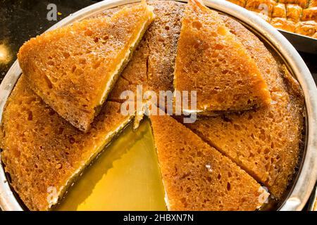 Dessert turc traditionnel, pudding au sirop Ekmek Kadayifi coupé dans un plateau métallique Banque D'Images