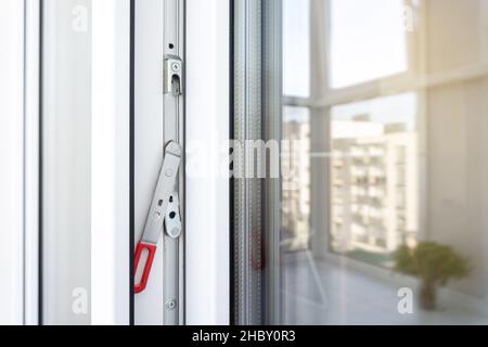 Cadre de porte de balcon en plastique blanc avec fixations.Gros plan du levier de transmission dissimulé.Accessoires et quincaillerie pour fenêtres et portes en UPVC. Banque D'Images