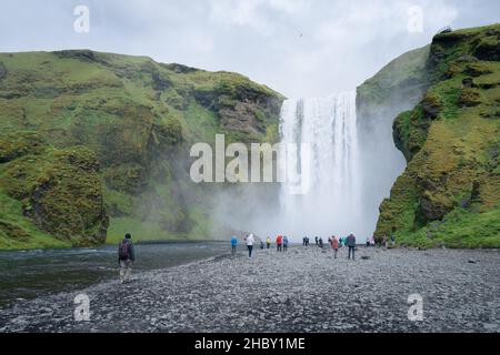 Skogafoss, Islande - 06.19.2017: Personnes marchant autour de la cascade de Skogafoss dans le sud de l'Islande lors d'une journée froide et nuageux de l'été islandais. Banque D'Images