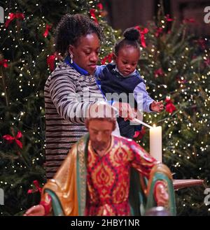 Photo précédemment non publiée du 08/12/21 des membres de la congrégation allumant une bougie à la crèche pendant 'Royal Carols - Together at Christmas', un concert de chants de Noël organisé par la duchesse de Cambridge à l'abbaye de Westminster à Londres, qui sera diffusé la veille de Noël sur ITV.Date de publication : le mercredi 22 décembre 2021. Banque D'Images