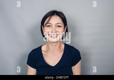Joyeuse belle femme aux cheveux courts noirs.Gros plan.Émotions de joie de bonheur.Sourire blanc neige. Banque D'Images