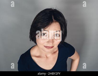 Joyeuse belle femme aux cheveux courts noirs.Vue de dessus.Émotions de joie de bonheur.Souriez. Banque D'Images