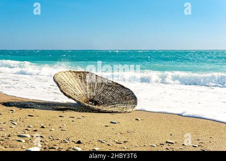 reed beach parasol dans le surf, soufflé par le vent pendant une tempête Banque D'Images
