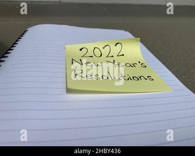 Texte de résolution de l'année 2022 écrit sur un pense-bête au-dessus d'un bloc-notes. Banque D'Images