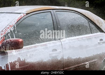 Entretien de voiture avec le lavage dans la mousse de voiture sous pression Banque D'Images