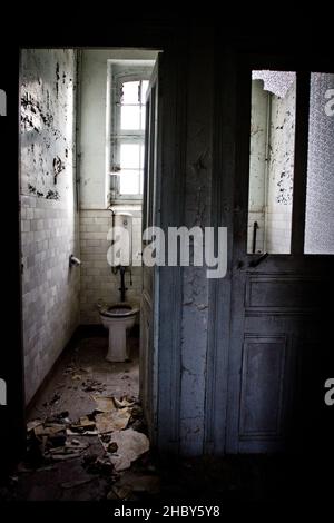 Un cliché vertical de l'intérieur de la salle de bains dans une maison abandonnée Banque D'Images