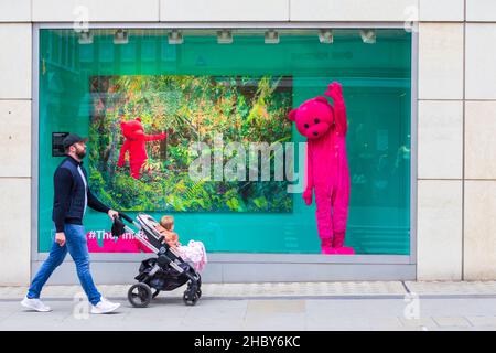 Luap Pink Bear Store, homme et tout-petit en poussette passe par la fenêtre du magasin avec grand ours rose luap, londres, royaume-uni Banque D'Images