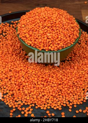 Lentilles rouges, non cuites, dans un bol en céramique vert Banque D'Images