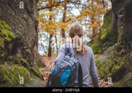 Femme avec sac à dos en forêt.Randonneur femelle entre les rochers en montagne. Banque D'Images