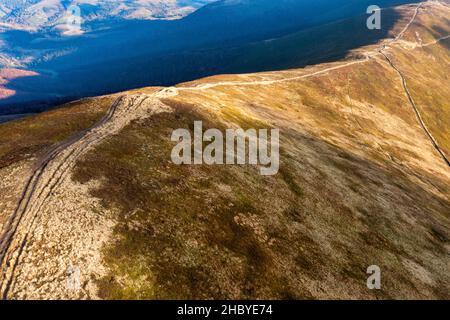 De longues allées étroites longeant la crête de haute montagne sous des nuages blancs moelleux flottant sur le ciel bleu sur une vue aérienne de jour ensoleillé Banque D'Images