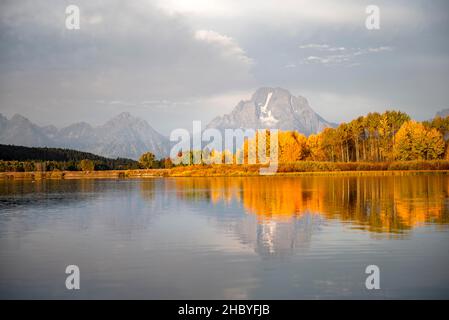 Mont Moran se reflète dans la rivière Snake, le matin à Oxbow Bend, arbres d'automne et Grand Teton Range, parc national de Grand Teton, Wyoming, États-Unis Banque D'Images