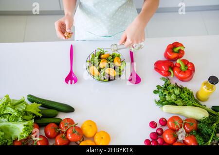 Au-dessus de la vue à grand angle de la belle fille expérimentée cuisine savoureuse salade utile délicieux verser l'huile dans la cuisine maison blanche claire à l'intérieur Banque D'Images