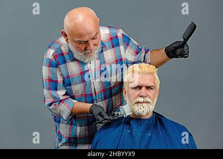 Coloration des cheveux en gris processus.Coiffeur appliquant une teinte colorée sur les cheveux de modèle d'homme.Publicité et concept de salon de coiffure.Professionnel Banque D'Images