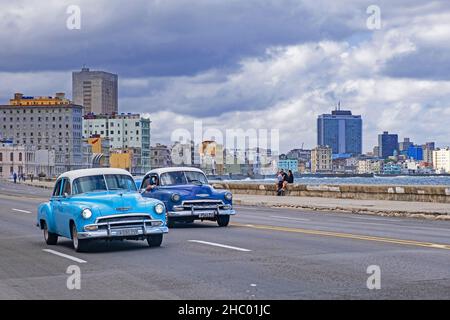 Deux voitures Chevrolet vintage 1950s sur la Malecón / Avenida de Maceo, avenue et digue le long de la ville la Havane sur l'île de Cuba Banque D'Images