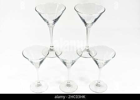 Les verres à cocktail martini vides se tiennent l'un sur l'autre sur fond blanc Banque D'Images