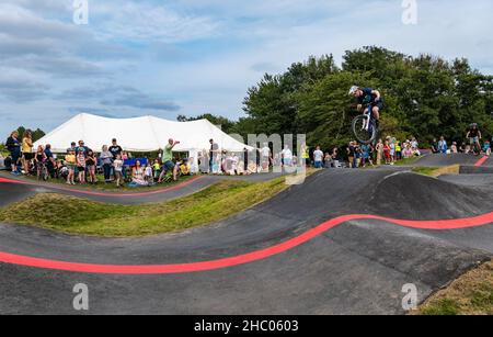 Garçon à vélo faisant une roue sur la piste de pompe Ormiston BMX, East Lothian, Écosse, Royaume-Uni Banque D'Images