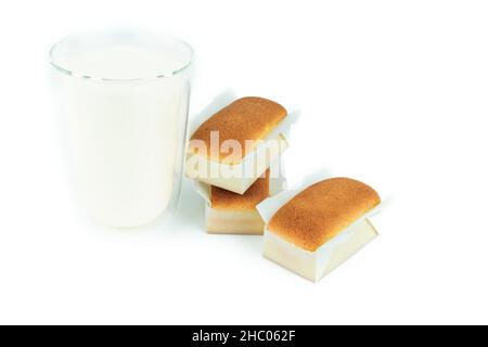 Trois madeleines faites à la main avec un verre à lait sur fond blanc.Pâtisserie boulangerie sur fond isolé. Banque D'Images