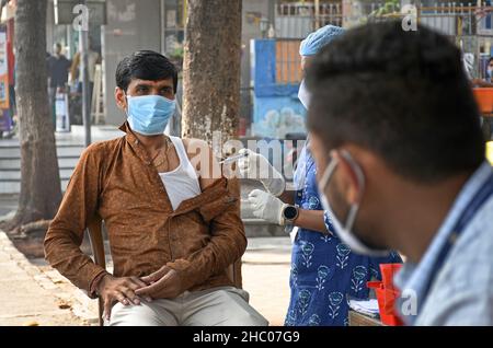 Mumbai, Inde.22nd décembre 2021.Un agent de santé administre une dose du vaccin contre le covishield à un homme lors d'une campagne de vaccination dans la rue Navi Mumbai.Le nombre de personnes vaccinées a augmenté tandis que les nouveaux cas de variante d'omicron augmentent.Crédit : SOPA Images Limited/Alamy Live News Banque D'Images