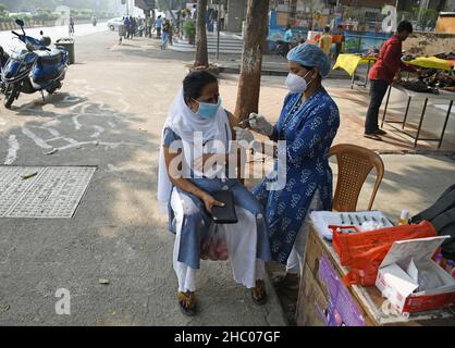 Mumbai, Inde.22nd décembre 2021.Un agent de santé administre une dose du vaccin contre le covishield à une femme lors d'une campagne de vaccination dans la rue Navi Mumbai.Le nombre de personnes vaccinées a augmenté tandis que les nouveaux cas de variante d'omicron augmentent.Crédit : SOPA Images Limited/Alamy Live News Banque D'Images