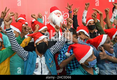 Mumbai, Inde.22nd décembre 2021.Le Père Noël pose avec des enfants défavorisés pour des photos lors d'un événement d'éducation à l'hygiène des mains à l'hôpital de Wockhardt.Crédit : SOPA Images Limited/Alamy Live News Banque D'Images