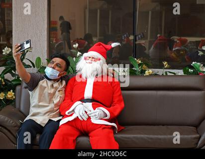 Mumbai, Inde.22nd décembre 2021.Un homme prend un selfie avec le Père Noël, lors d'un événement d'éducation à l'hygiène des mains à l'hôpital de Wockhardt.Crédit : SOPA Images Limited/Alamy Live News Banque D'Images