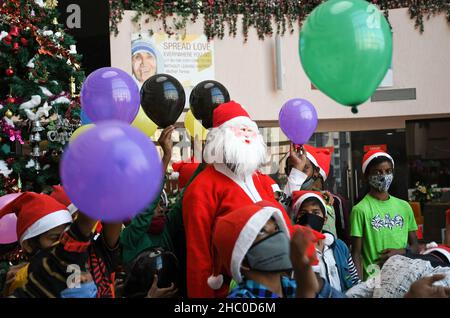 Mumbai, Inde.22nd décembre 2021.Le Père Noël pose avec des enfants défavorisés pour des photos lors d'un événement d'éducation à l'hygiène des mains à l'hôpital de Wockhardt.Crédit : SOPA Images Limited/Alamy Live News Banque D'Images