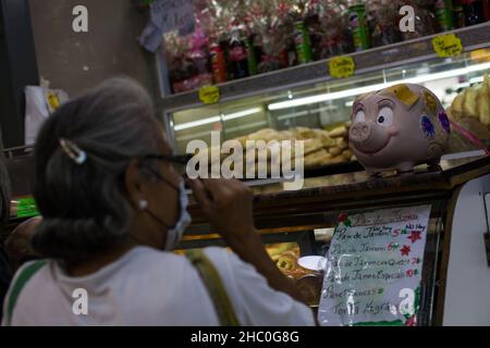 Caracas, Venezuela.22nd décembre 2021.Une banque de porc se tient dans une boulangerie à l'heure de Noël.Pendant la saison de Noël, les commerçants du Venezuela placent des banques porcines en forme de cochon dans leurs magasins et leurs étals.Les clients sont censés leur déposer un pourboire de Noël.(À dpa 'coloré 'cochons de Noël' pour les pourboires au Venezuela') Credit: Boris Vergara/dpa/Alamy Live News Banque D'Images