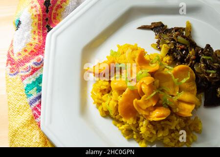 Goias, Brésil – 22 décembre 2021 : plat blanc avec riz à la pulpe de pequi et viande à la banane.Nourriture végétalienne.Pequi est un fruit typique de Banque D'Images