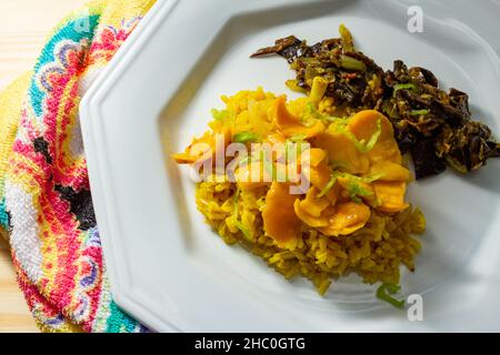 Goias, Brésil – 22 décembre 2021 : plat blanc avec riz à la pulpe de pequi et viande à la banane.Nourriture végétalienne.Pequi est un fruit typique de Banque D'Images