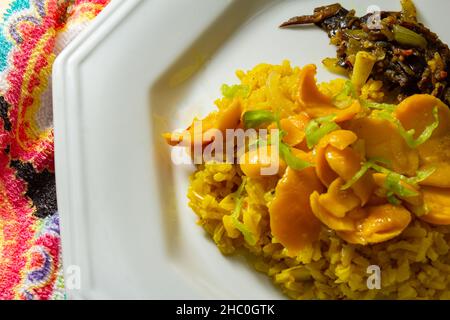 Goias, Brésil – 22 décembre 2021 : plat blanc avec riz à la pulpe de pequi et viande à la banane.Nourriture végétalienne.Pequi est un fruit typique de Banque D'Images