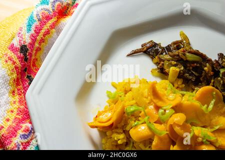 Goias, Brésil – 22 décembre 2021 : plat blanc avec riz à la pulpe de pequi et viande à la banane.Nourriture végétalienne.Pequi est un fruit typique de Banque D'Images