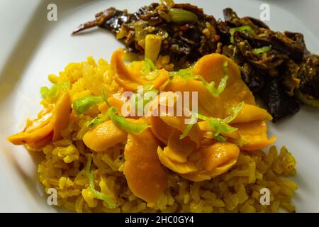 Goias, Brésil – 22 décembre 2021 : plat blanc avec riz à la pulpe de pequi et viande à la banane.Nourriture végétalienne.Pequi est un fruit typique de Banque D'Images