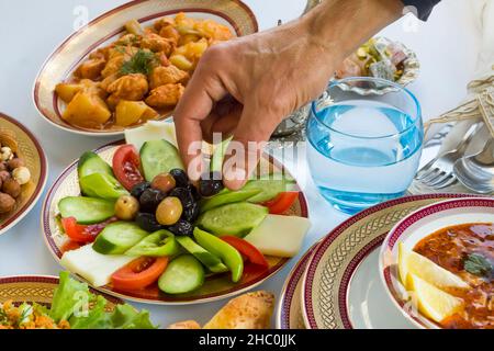 Prenez à la main l'olive noire sur la table de Ramadan-Iftar, gros plan Banque D'Images