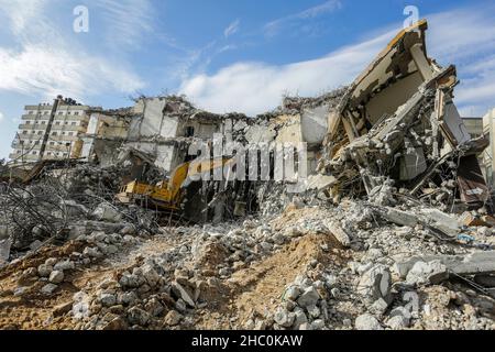 Gaza, Palestine.22nd décembre 2021.Un bulldozer enlève les débris de la tour Al-Jawharah qui a été touchée par les frappes aériennes israéliennes pendant les combats israélo-palestiniens en mai 2021.Crédit : SOPA Images Limited/Alamy Live News Banque D'Images