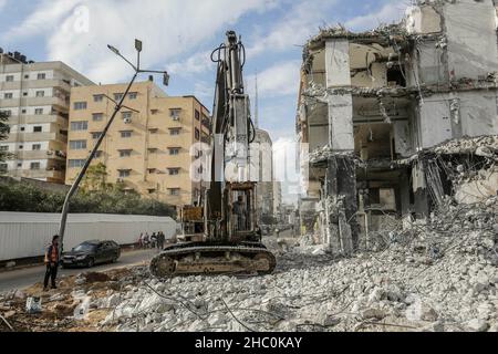 Gaza, Palestine.22nd décembre 2021.Les travailleurs palestiniens retirent les décombres à l'aide d'un bulldozer de la tour Al-Jawharah qui a été frappée par des frappes aériennes israéliennes pendant les combats israélo-palestiniens en mai 2021.Crédit : SOPA Images Limited/Alamy Live News Banque D'Images