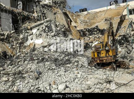 Gaza, Palestine.22nd décembre 2021.Un bulldozer enlève les débris de la tour Al-Jawharah qui a été touchée par les frappes aériennes israéliennes pendant les combats israélo-palestiniens en mai 2021.Crédit : SOPA Images Limited/Alamy Live News Banque D'Images