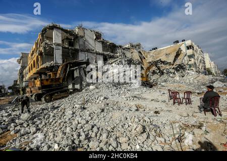 Gaza, Palestine.22nd décembre 2021.Un bulldozer enlève les débris de la tour Al-Jawharah qui a été touchée par les frappes aériennes israéliennes pendant les combats israélo-palestiniens en mai 2021.Crédit : SOPA Images Limited/Alamy Live News Banque D'Images