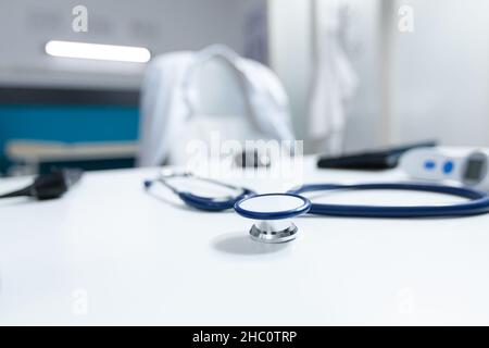 Gros plan d'un stéthoscope médical debout sur une table dans un cabinet médical vide pendant la consultation de la maladie.Milieu de travail hospitalier où personne n'est équipé d'outils de soins de santé.Concept de médecine Banque D'Images