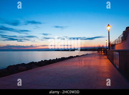 Grado, Italie - 7 juillet 2021: Jouer avec des ombres en fin de soirée dans l'heure bleue après le coucher du soleil au bord de la mer Banque D'Images