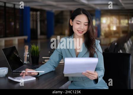 Femme d'affaires avec document de données et calcul des numéros de budget.Finance, conseiller, factures, concept fiscal. Banque D'Images