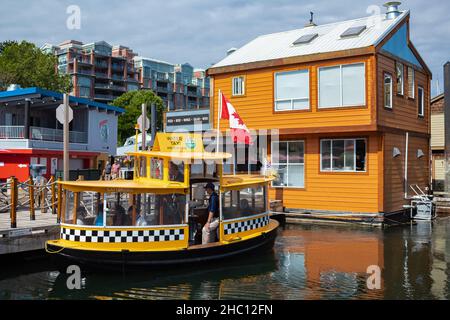 Floating Home Village des Houseboats colorés et bateau-taxi.Fisherman's Wharf Reflection Inner Harbour, Victoria C.-B., Canada Pacifique Nord-Ouest.La zone a f Banque D'Images