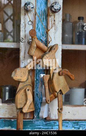 Lapins en bois suspendus sur un vieux placard vintage. Banque D'Images