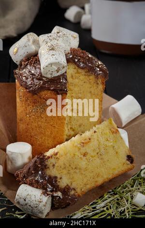 Gâteau de Pâques en tranches de pâte moelleuse aux fruits confits, recouvert de glaçage au chocolat et de guimauves Banque D'Images