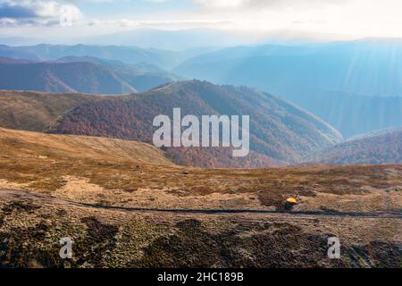 De longues allées étroites longeant la crête de haute montagne sous des nuages blancs moelleux flottant sur le ciel bleu sur une vue aérienne de jour ensoleillé Banque D'Images