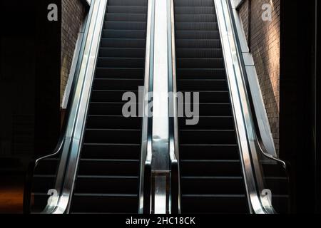 Escaliers roulants.Deux escaliers mécaniques dans le centre commercial jusqu'à la lumière.Entreprise ou architecture ou construction ou shopping ou photo de fond souterraine Banque D'Images