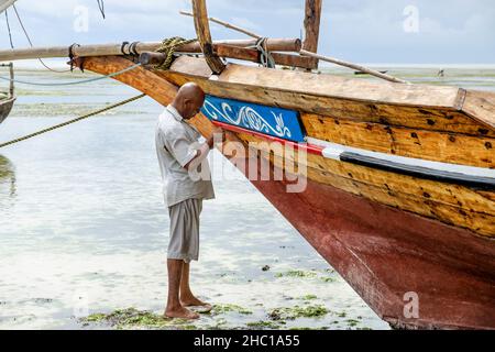 Les pêcheurs réparent leurs dhuws sur les plages blanches de Zanzibar Banque D'Images