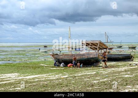 Les pêcheurs réparent leurs dhuws sur les plages blanches de Zanzibar Banque D'Images