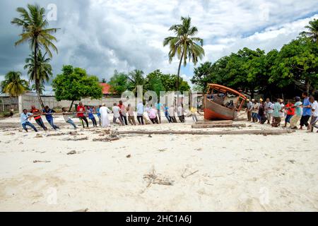 Les pêcheurs réparent leurs dhuws sur les plages blanches de Zanzibar Banque D'Images