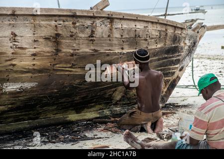 Les pêcheurs réparent leurs dhuws sur les plages blanches de Zanzibar Banque D'Images