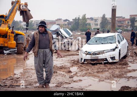 Erbil, Irak.17th décembre 2021.Des gens débadent les débris dans une zone touchée par des inondations soudaines à Erbil, dans le nord de l'Irak, le 17 décembre 2021.Le nombre de décès dus aux inondations soudaines causées par des pluies torrentielles dans le nord de l'Irak est passé à 11 vendredi.Credit: Dalshad Al-Daloo/Xinhua/Alay Live News Banque D'Images